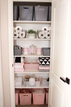 an organized closet with baskets and other items in pink, white and grey colors on shelves