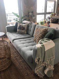 a living room with a gray couch and some pillows on top of the couches