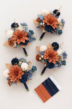 three bridal bouquets with blue, orange and white flowers