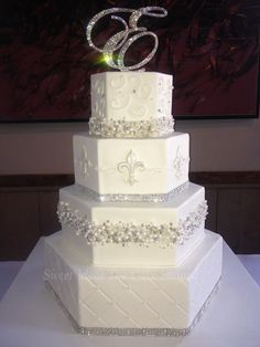 a three tiered white wedding cake sitting on top of a table