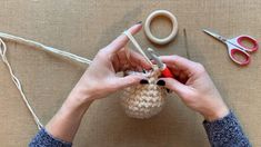 someone is working on their knitting project with yarn and scissors, along with crochet hooks