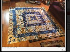 a blue and yellow patchwork rug on the floor in a living room with hardwood floors