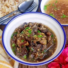 a bowl of beef stew next to a plate of rice