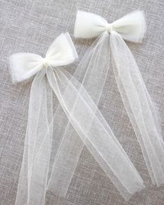 two white bows are attached to tulle