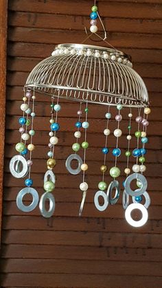 a wind chime hanging from the side of a wooden wall next to a window