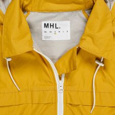 a yellow jacket with white zippers and a label on the front that says mhl