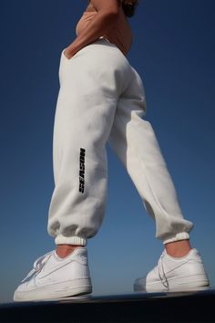 "Our white \"SEASON\" joggers are high on quality and low on well...nothing! Super soft, comfy and stylish and made of 100% cotton. Can easily be styled up or down, and will both look and feel amazing paired with anything. We're thinking cosy winter days and long summer evenings. Maybe the best quality joggers you've ever had?  - Colour: White - Drawstring waist - Cuffed ankles - Can be worn full length or rolled into cropped - Super soft fleece lining - Pockets - Elasticated waistband with draw Comfortable White Pants For Spring, White Comfortable Pants For Spring, Comfortable White Spring Pants, Spring Letter Print Joggers For Loungewear, Sporty Cotton Joggers With Logo Print, Cotton Sporty Joggers With Logo Print, Sporty Relaxed Fit Pants With Logo Print, Relaxed Fit Sportswear Joggers With Letter Print, Athleisure Joggers With Letter Print And Relaxed Fit