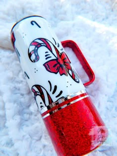 a red and white case sitting on top of a snow covered ground next to a cell phone