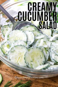 creamy cucumber salad in a glass bowl with a spoon