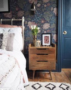 a bedroom with blue walls and floral wallpaper