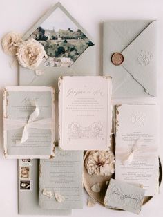 the wedding stationery is laid out on top of each other, including an envelope and two