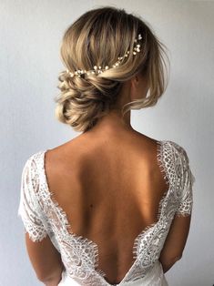 the back of a woman's wedding dress with pearls on her head and shoulders