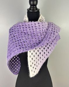 a purple and white knitted scarf on a mannequin