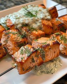 salmon skewers with cream sauce and dill sprinkled on them