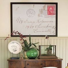 a green vase sitting on top of a wooden dresser next to a white chair and table