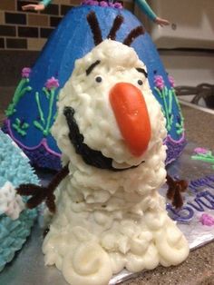 there is a cake made to look like a snowman with an orange nose and nose