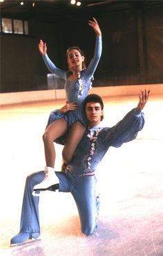 a man riding on the back of a woman in a blue leorboard