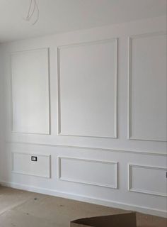 an empty room with white paneled walls and no furniture on the floor in front of it