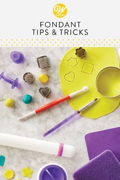 fondant tips and tricks on a table with cookie cutters, paintbrushes, and other crafting supplies