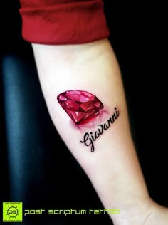 a woman's arm with a tattoo on it that reads giaanni and has a pink diamond