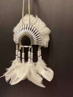 a white feather dream catcher hanging on a wall