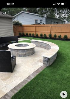 a backyard with artificial grass and an outdoor fire pit