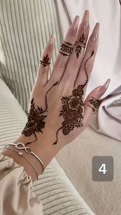 a woman's hand with henna tattoos on it