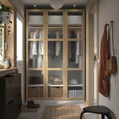 an empty room with glass doors and wooden shelves on the wall next to a chair