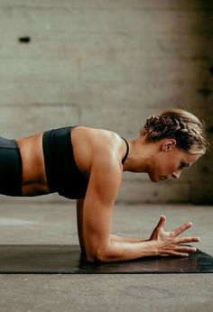 a woman is doing push ups on her stomach