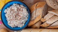 bread and dip in a blue bowl on a cutting board next to other breads