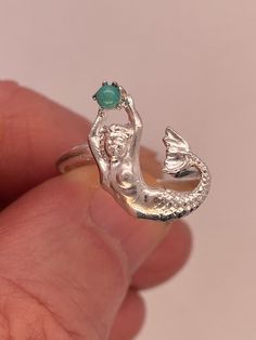 Sterling Art Nouveau mermaid ring is 17.5mm top to bottom by 12.2mm wide with 2.5mm turquoise stone. Shank is 2 mm wide at top, tapering to 1.6mm at bottom. Size 7.25 and sizeable. 2.5g Also available in 10k, 14k, 18k yellow, white, and pink gold. inquire for prices. Mermaid Rings, Art Nouveau Mermaid, Jewelry Closet, Mermaid Core, Mermaid Ring, Grade 8, Recycled Metal, Pearl Ring, Pearl Pendant