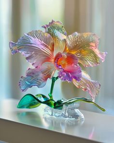 a glass flower sitting on top of a table