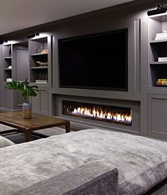 a living room filled with furniture and a flat screen tv mounted to the side of a wall