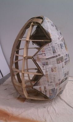 a paper mache sculpture sitting on top of a white sheet covered floor next to a wall