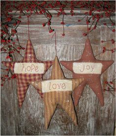 three wooden stars hanging on a wall with the words hope, love and joy