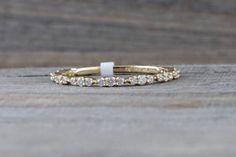 an image of a wedding ring with diamonds on the inside and outside, sitting on a wooden surface