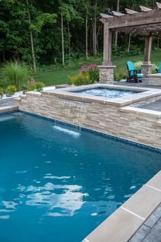 an outdoor swimming pool surrounded by landscaping