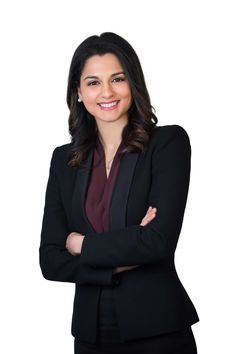 a woman in a black suit and tie posing for a photo with her arms crossed