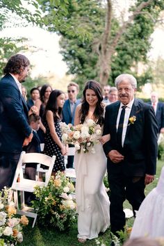 an older man and woman walking down the aisle at a wedding ceremony with their parents