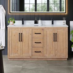 a bathroom vanity with two sinks and mirrors