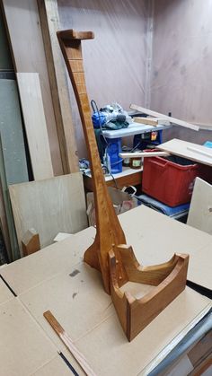 a wooden boat sitting on top of a table next to plywood and other woodworking supplies