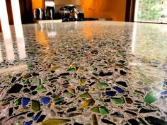 a kitchen counter top covered in lots of different colored glass tiles and pebbles on it