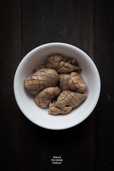 a white bowl filled with some kind of food on top of a wooden table and the words how to clean & prepare pig's kidney for cooking