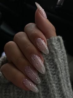 Perfectly sculpted almond nails meet delicate rhinestones for a look that whispers luxury. These NYE-ready nails add a hint of sparkle to every toast and midnight wish. Jems On Nails, White With Rhinestones Nails, French Manicure Pearl, White Reflective Nails, Nails Inspo January, Ring Finger Nail Art Designs, Silver Nail Charms, Square Nye Nails, Clean Nails Aesthetic Design