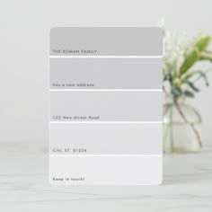 there is a white vase with flowers in it and the color swatches are gray