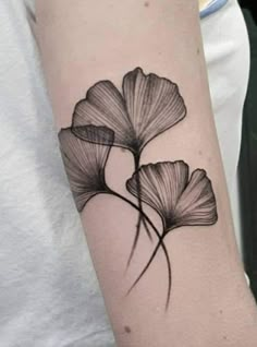 a black and white flower tattoo on the arm