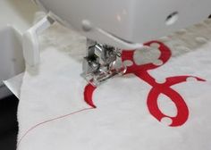 the sewing machine is next to the red and white piece of fabric that has been sewn