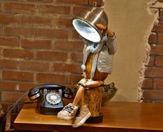 a wooden table topped with a lamp and a phone