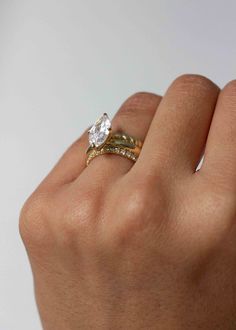 a woman's hand with a ring on it and a diamond in the middle