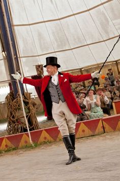 a man in a red jacket and top hat dancing